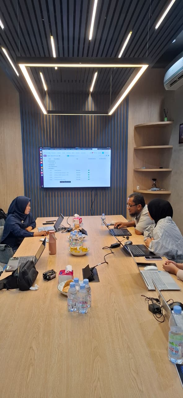 Tim NURATEK dan Casakha di meja konferensi dengan dashboard Odoo di layar dinding