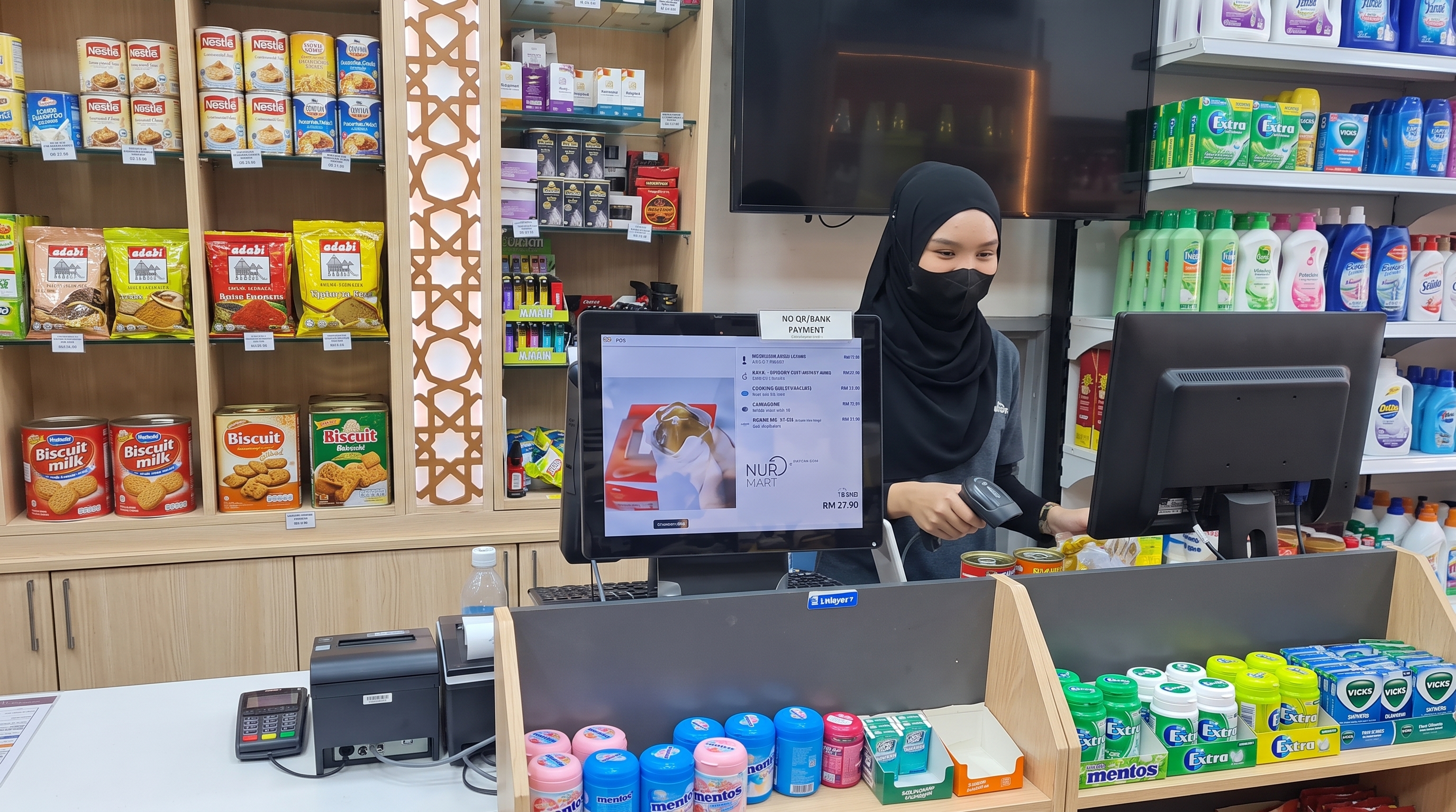 Kasir menggunakan sistem POS Odoo dengan scanner barcode dan layar pelanggan di toko retail