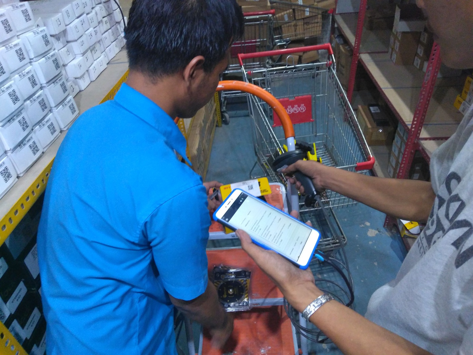 Two staff members counting rack stock with a scanner and a mobile app